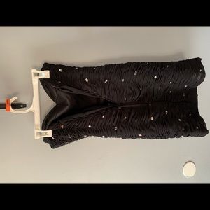 Black form fitting dress, with crisscross back when tied and strapless.